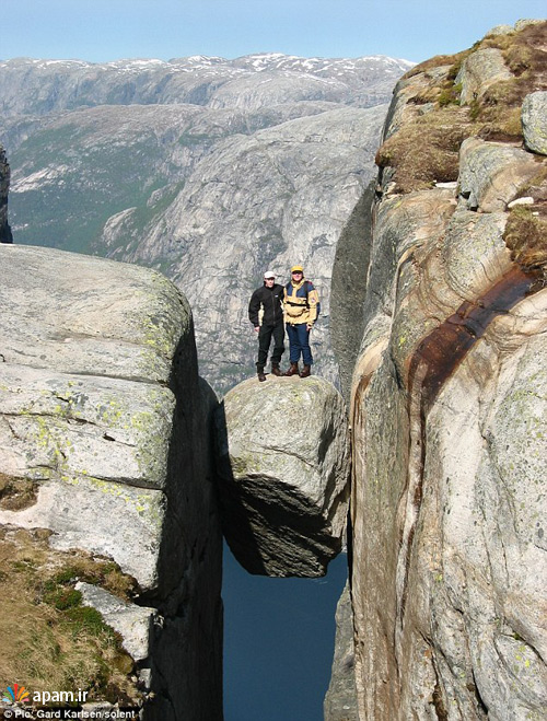 ایستادن کوهنوردان ماجراجو روی تخته سنگی خطرناک